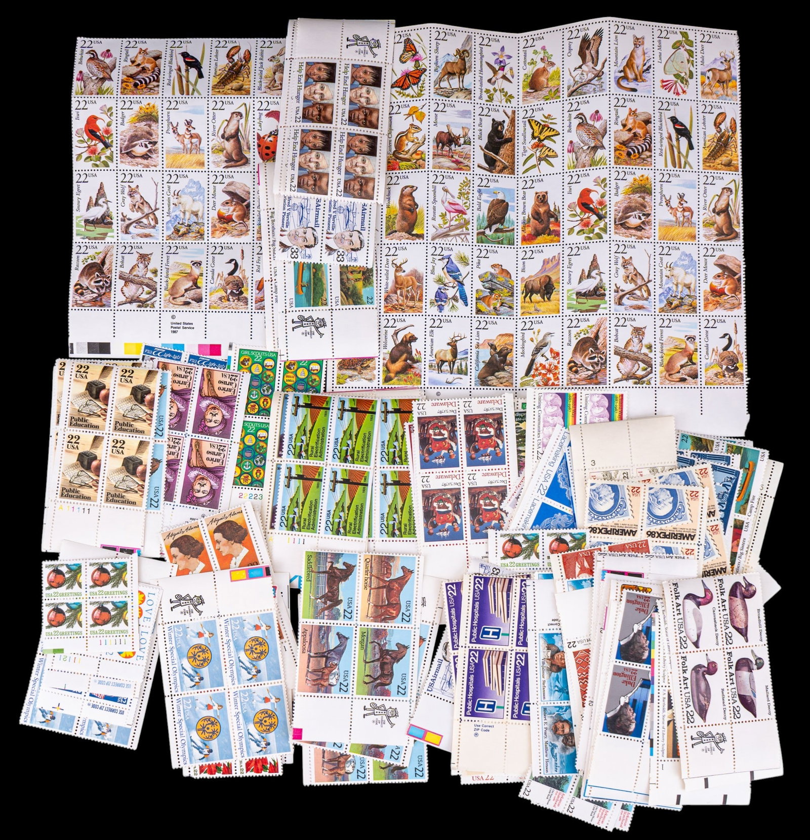 Collectible U.S. Postage Stamps: A alrge assortment of collectible U.S. postage stamps in 4-square sheets including denominations such as 22 cents and 33 cents.