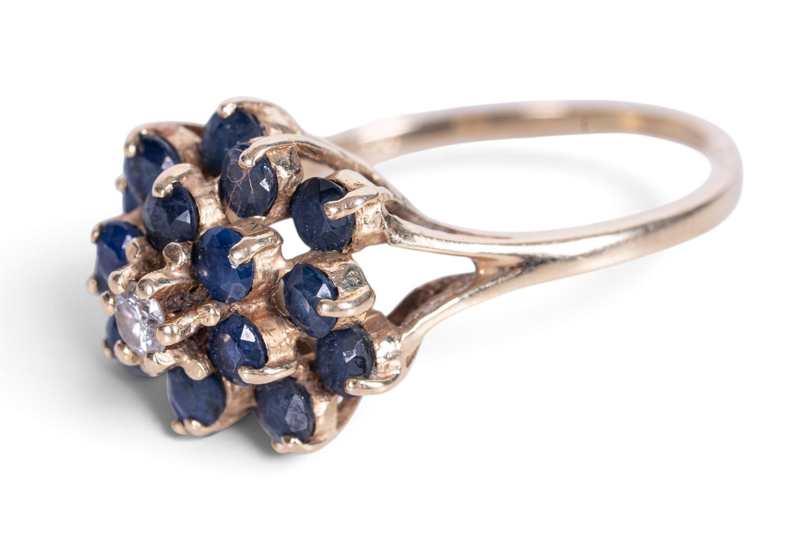 14K Gold Sapphire & Diamond Cluster Ring: 14K gold sapphire and diamond cluster ring. Set with a round brilliant-cut diamond center surrounded by round-cut blue sapphires in a floral cluster mounting. Ring size US 9.5. Marked 14K inside band.