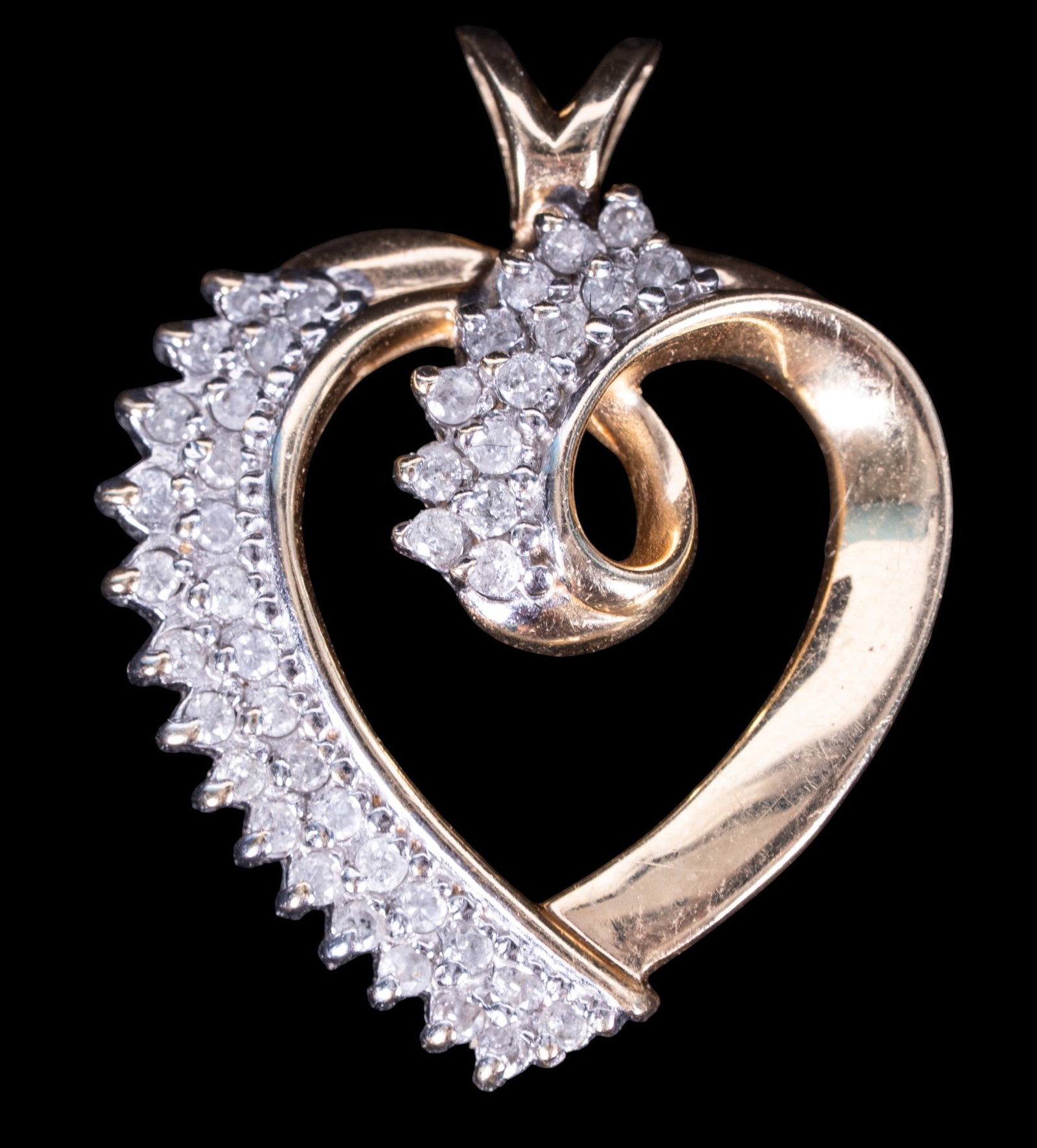 14K Gold Diamond Heart Pendant: 14K gold diamond heart pendant with open-heart design set with numerous round brilliant-cut diamonds in a graduated swirl motif. Marked with hallmark and 14k to reverse. Weighs approx. 4.8 grams.