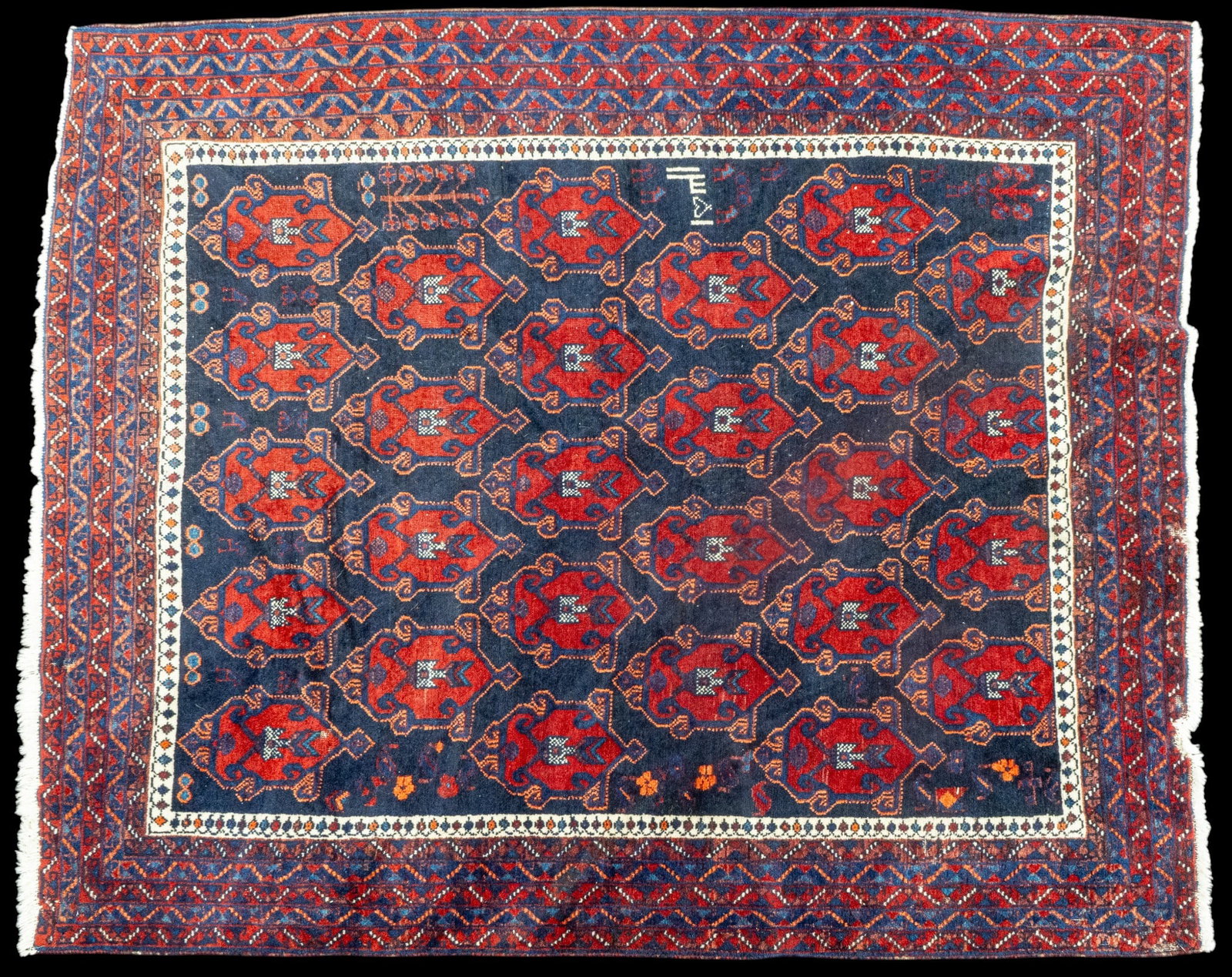 Signed Bohkara Rug: Unusual red on blue ground and wide border. Signature in white at center border edge and a small tree of life motif on same side. Approx 5'3" x 6'3"
