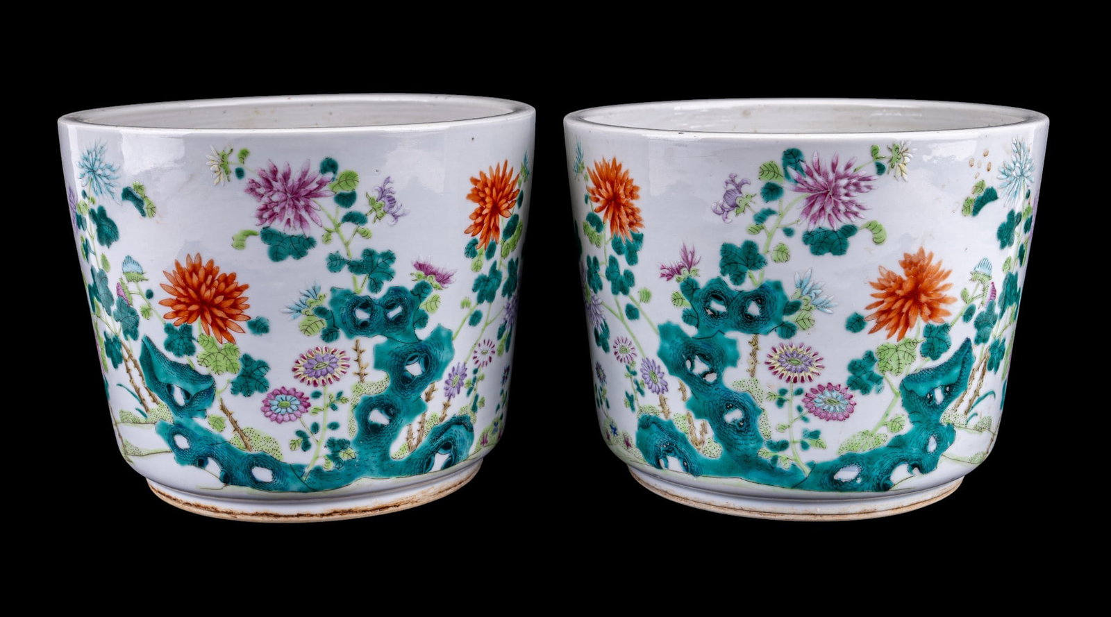 19/20th C Chinese Famille Rose Porcelain Planters: A pair of 19/20th C Chinese Famille Rose Canton porcelain planters featuring a colorful floral motif, with holes for draining, both measure approx. 9.25" diam x 7.5". From the Estate of Carol and Geor