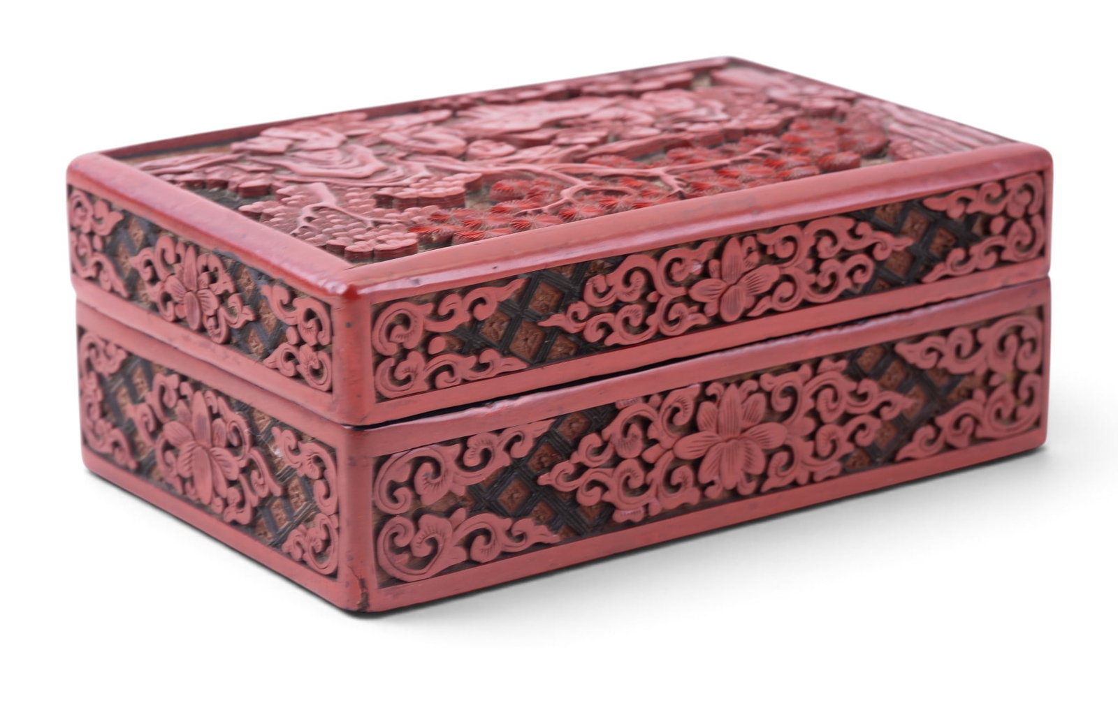19th C Carved Cinnabar Lidded Box: Chinese carved cinnabar lacquer rectangular lidded box, 19th century. Carved in relief with a figural garden scene. Measures approx. 7" W x 2.5" H x 4.5" D.