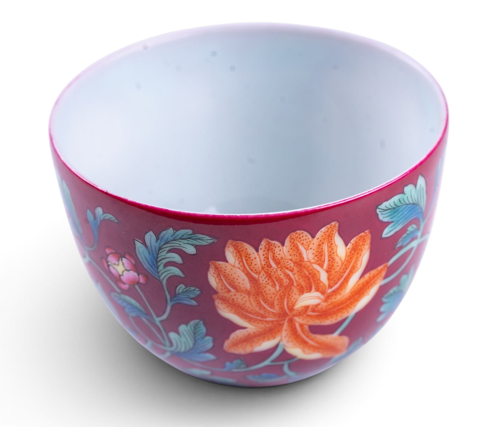 Chinese Ruby-Ground Floral Teacup: Chinese porcelain tea cup, decorated in famille rose enamels with orange and pink flowering blooms on leafy stems, reserved against a ruby red ground. Underside bearing a square 4-character mark. Meas