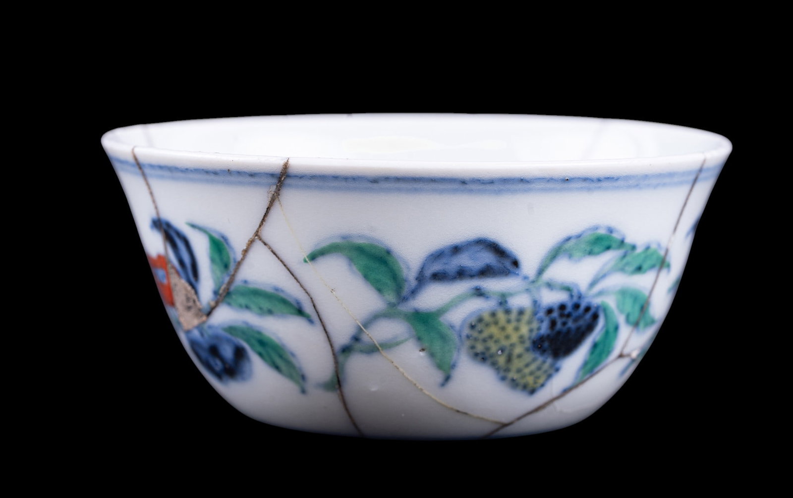 Antique Chinese Wucai Fruit Cup: Chinese porcelain cup, decorated in underglaze blue and polychrome enamels with fruiting branches and foliage, underside bearing a square six-character mark. Extensively repaired as seen in photograph