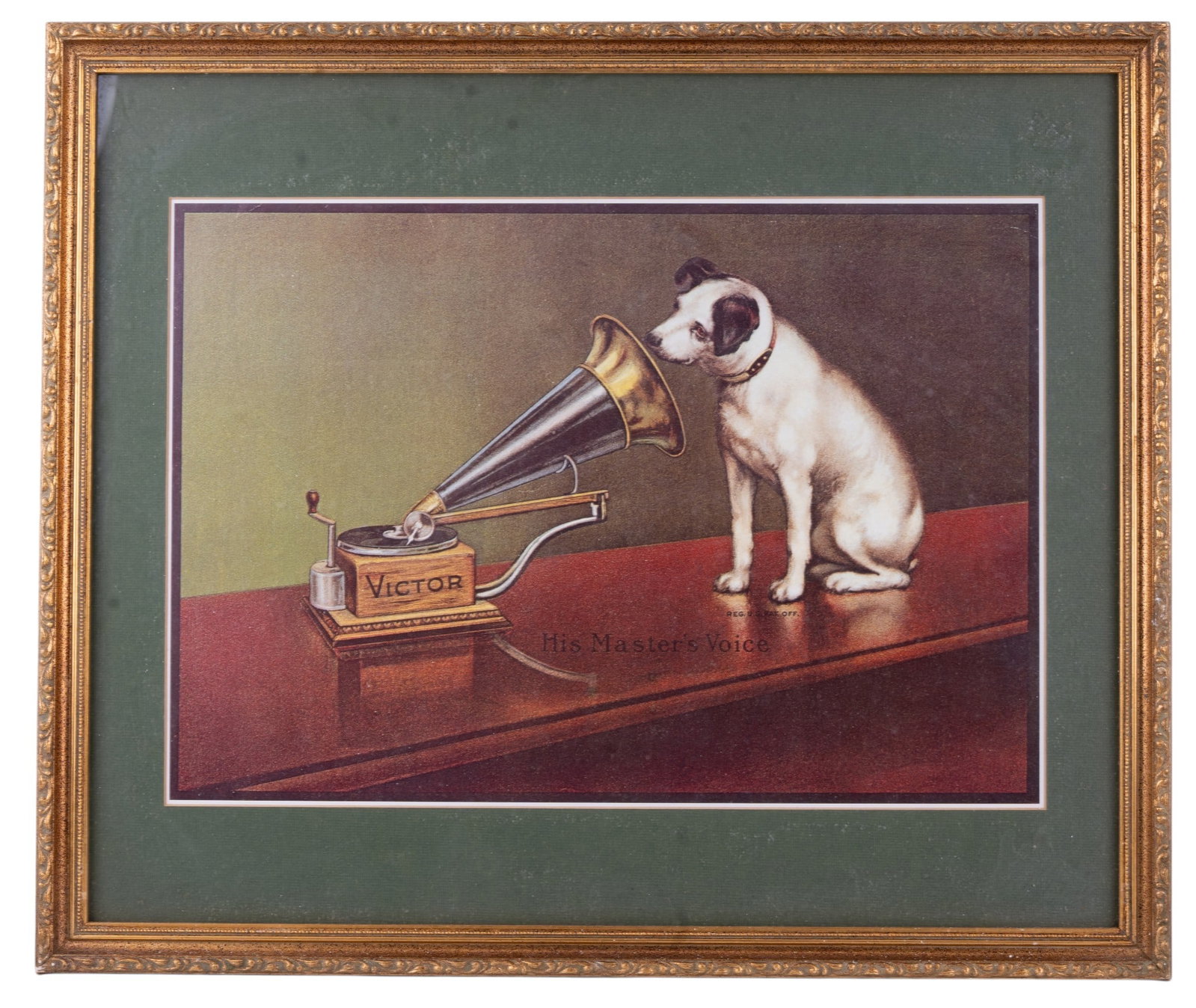His Master's Voice Print: Framed print of "His Master's Voice". The image shows a terrier-mix dog named Nipper listening intently to a wind-up disc gramophone. set in a green mat and gilt wood frame. Measures approx. 21 3/4"