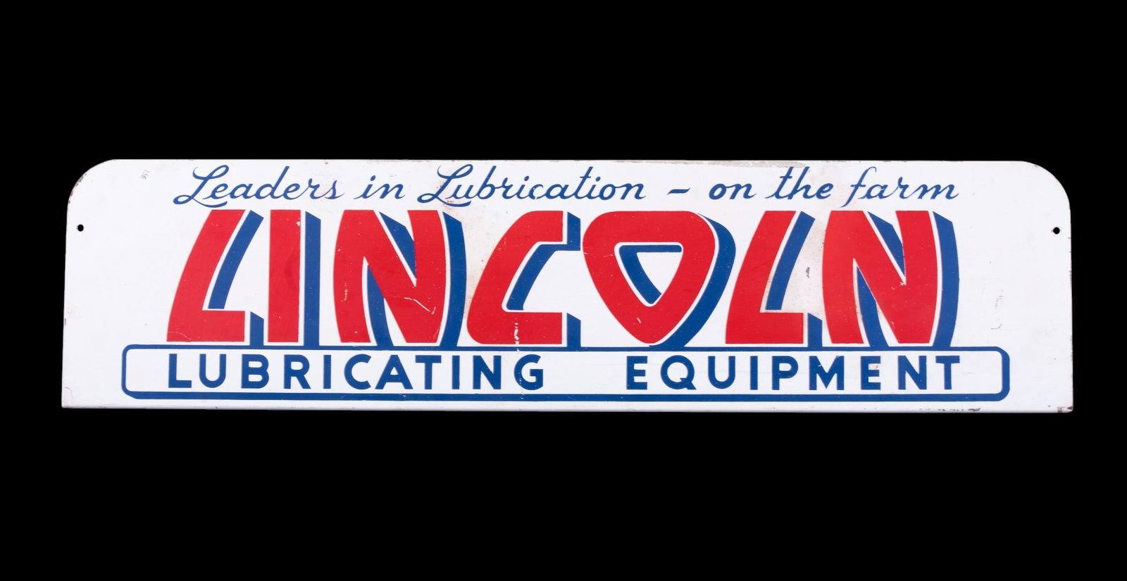 Lincoln Lubricating Equipment Metal Sign: Rectangular metal advertising sign for Lincoln Lubricating Equipment, featuring bold red and blue text and the slogan 'Leaders in Lubrication - on the farm.' Measures 28 inches wide by 7 inches high.