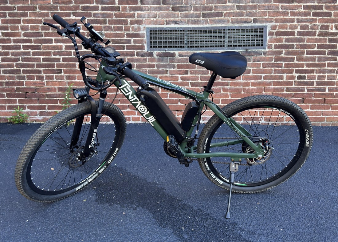 Tentaquil Electric Mountain Bike With Accessories: Tentaquil electric mountain bike featuring a detachable battery, Shimano gear shifter, C9 Cloud-9 seat, and Billy Goat tires. Includes key, charger cord, battery pack, and instruction manual. Sold as