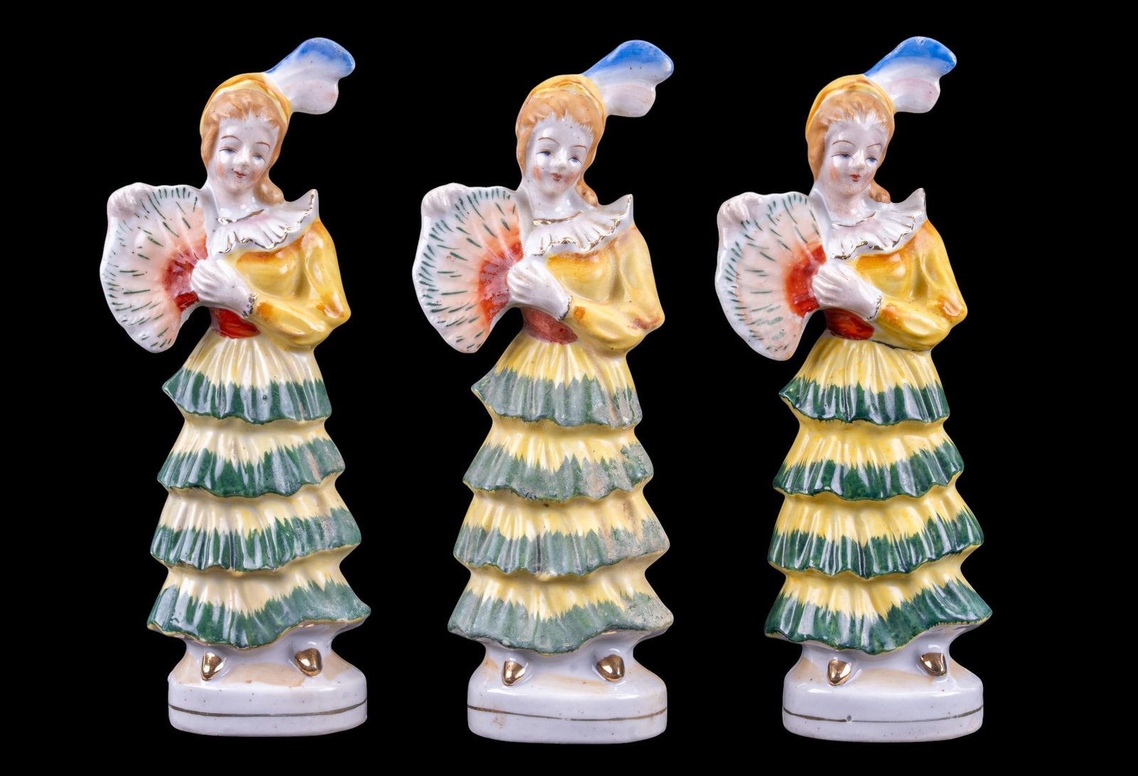 3 Porcelain Ladies with Fans, Occupied Japan: Three matching porcelain figurines of ladies holding fans, each hand-painted in yellow, green, and blue accents with gold detail. Each is stamped Made in occupied Japan and measures approximately 8.5