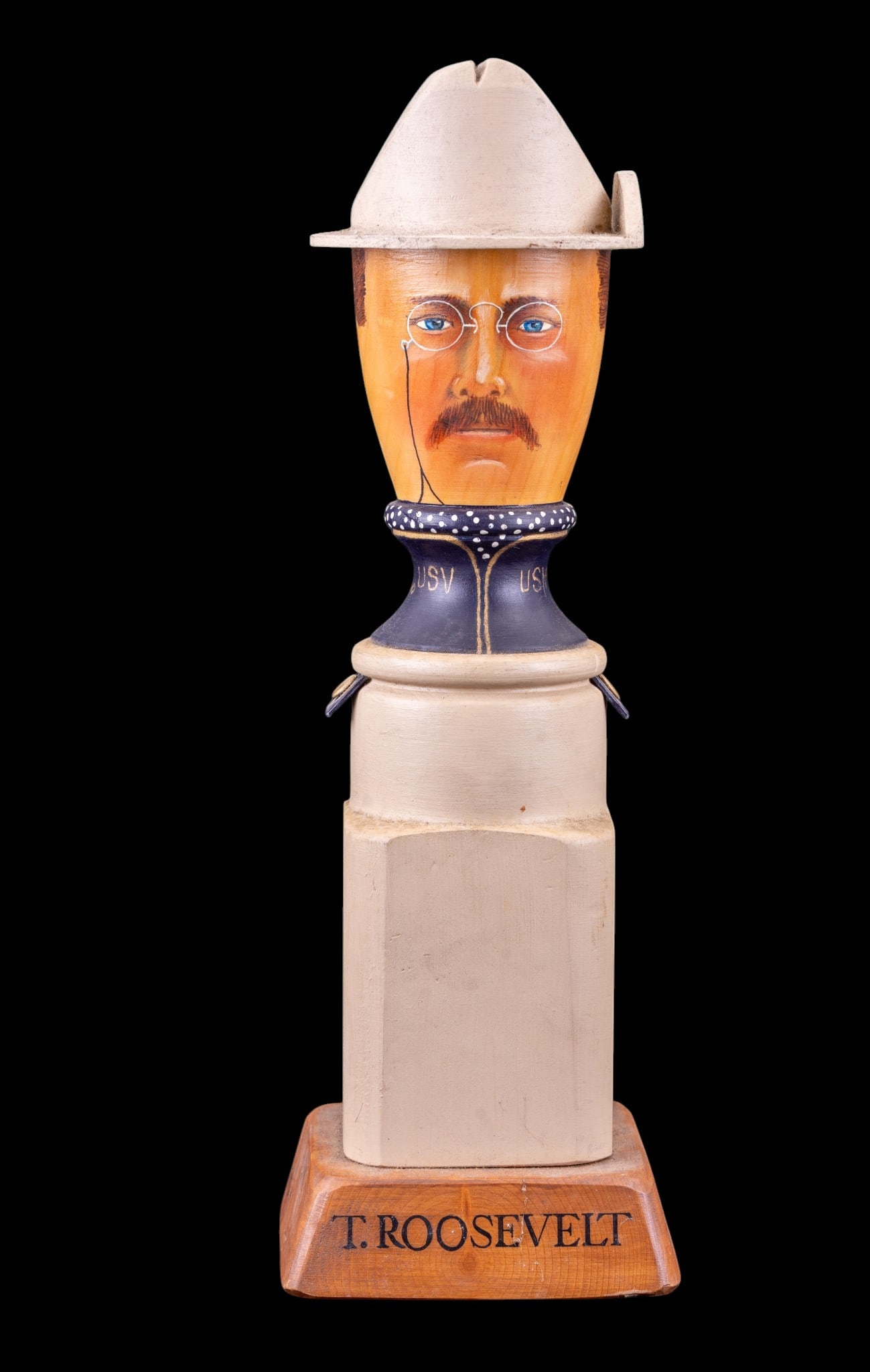 Bill Tait Wood Figure of T. Roosevelt: Hand-painted wood figurine of Theodore Roosevelt by Bill Tait Commercial Art. Features a detailed bust with glasses and hat, mounted on a square wooden base labeled "T. Roosevelt." Stands 14 1/2