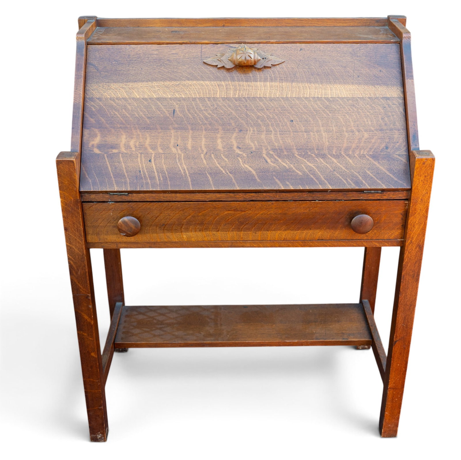 Victorian Oak Slant Front Desk: A Victorian oak slant front desk featuring a carved butternut and leaf handle on the fold down top, measures approx. 32" W 16" D x 41" H. Special considerations should be made for pick up/shipping.