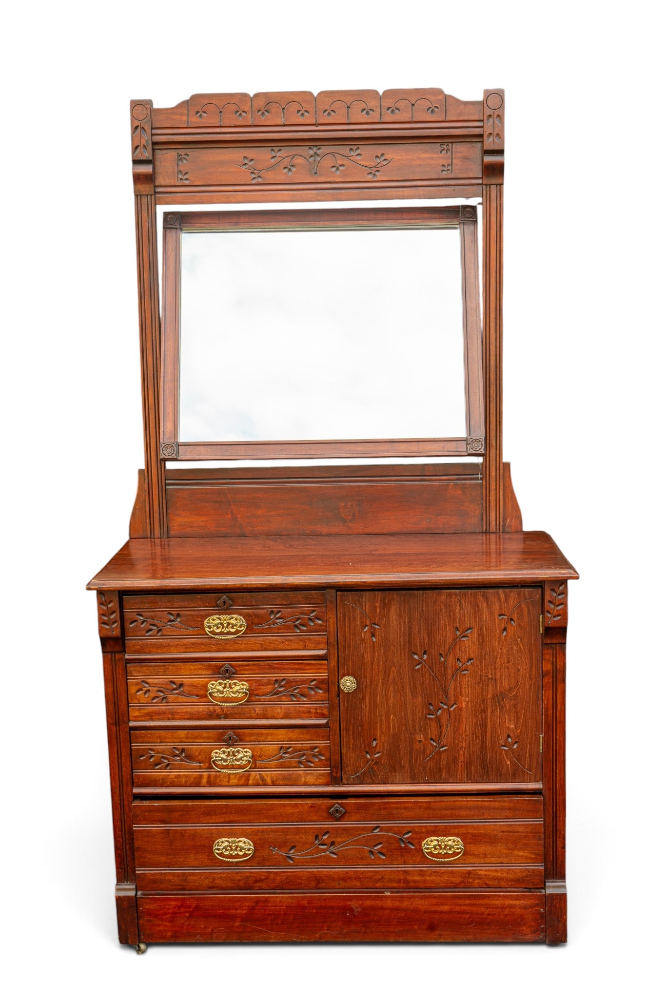 Early Carved Cherry Floral Dresser with Mirror: An early cherry wood carved dresser and swivel mirror featuring a carved floral design, brass casters, and dovetail joinery. Dresser measures approx. 42" W x 18" D x 36" H, mirror measures approx.