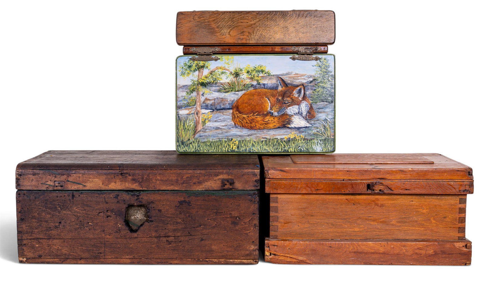 Painted Wood Lap Desk and Storage Trunks: An early wooden lap desk with brass hinge featuring a handpainted hinged desktop depicting a fox laying in nature, signed in the lower left corner 'Linda Lighiy', measures approx. 18" W x 17" D x 4.5"
