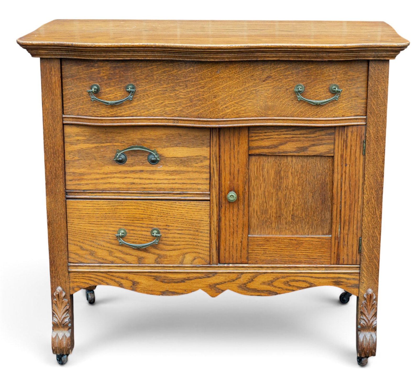 Victorian Oak Wash Basin Cabinet: A Victorian oak wash basuin cabinet featuring wood casters and carved feet, note some loss by the cabinet door, no mirror included, measures approx. 33" W x 19" D x 30" H. Special considerations
