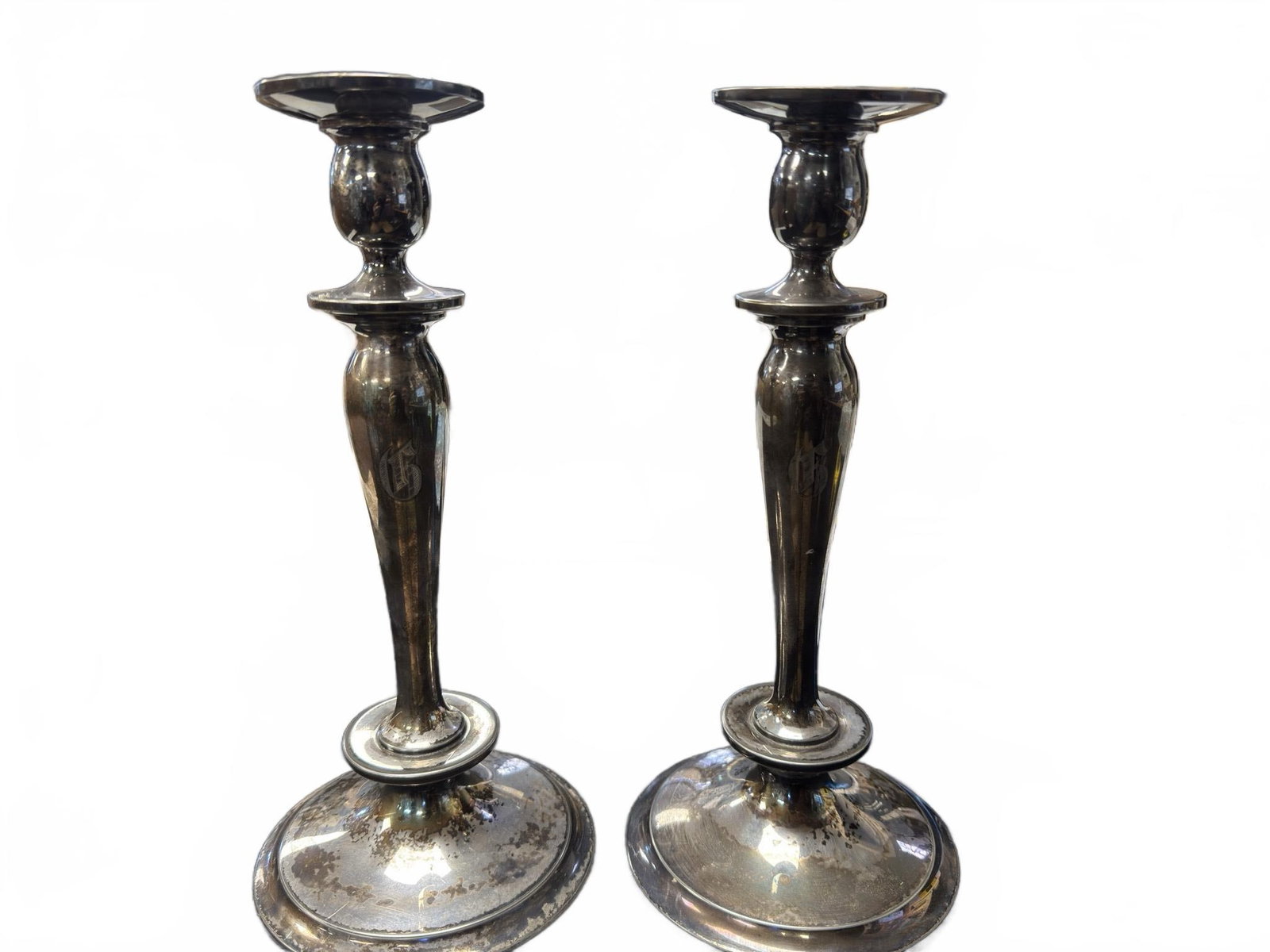 Hartford Silver Co. Quadruple Plated Candlesticks: Hartford Silver Plate Co. candlesticks, marked as quadruple plated with model number 97. Each features a monogrammed design on the stem and a traditional round base. Both show signs of tarnish and sur