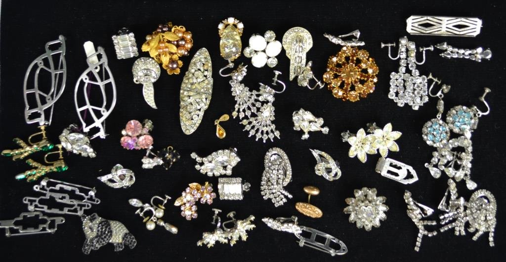 Lot of Rhinestone Costume Jewelry: Rhinestone costume jewelry lot includes a mixture of clip on earrings, scarf holders, and assorted brooches with designers of Weiss, Coro Duette, Panda Bear, some made in Austria