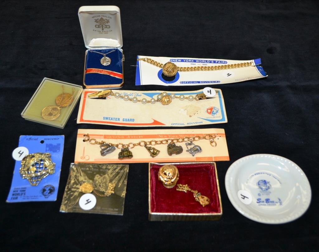 Jewelry Grouping from 1964 Worlds Fair: Jewelry grouping includes two pins, bracelet, and sweater guard, sterling silver pita medal with chain, NY Worlds Fair Charms Bracelet, 1964 tie tack, 1964-65 pendants as well as a Sue Brett advertisi
