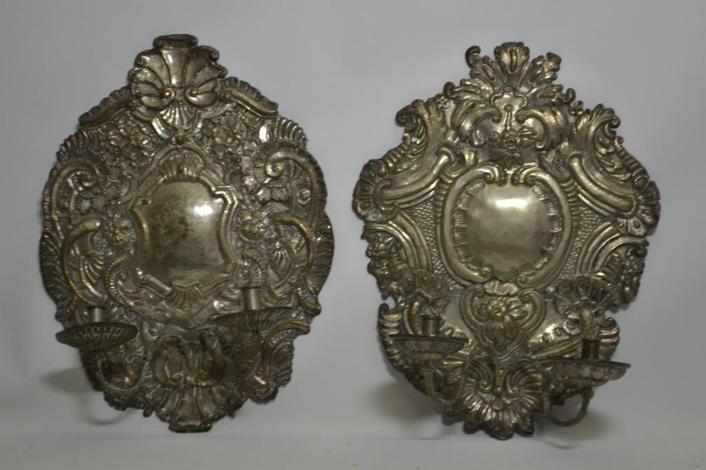 Pair of Silvered Copper Wall Sconces: Pair of silvered copper wall sconces, each with two candle cups on stems, ornately chased, measures 23.5"H x 17"W x 8.5"D