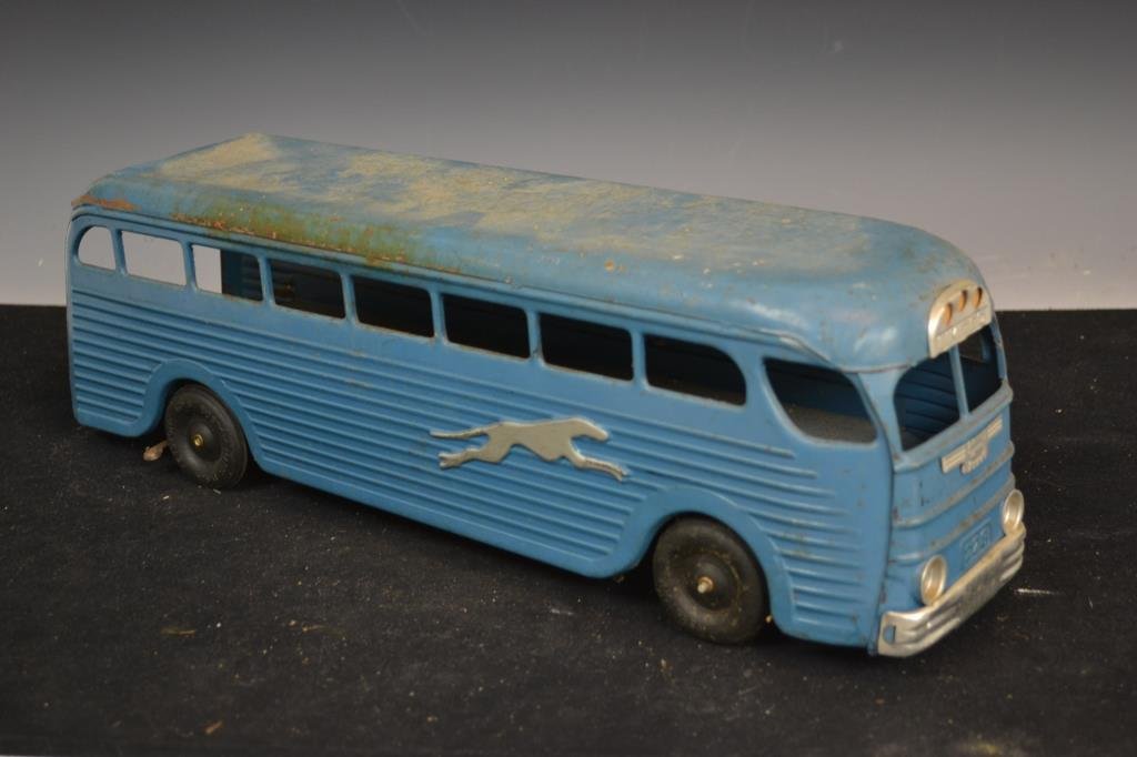 Midcentury Greyhound Bus Toy: Midcentury Greyhound bus toy with traction windup, appears to be in working condition, retaining paint and decorations, measures appx 6"H x 17"L x 5"D