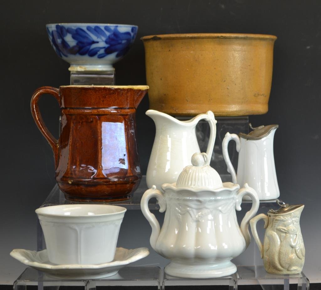Stoneware and Ironstone Grouping: Grouping includes; an unmarked and undecorated cake crock, a stone ware Bennington style pitcher, two syrups, a Flow Blue bowl in as-is condition,
