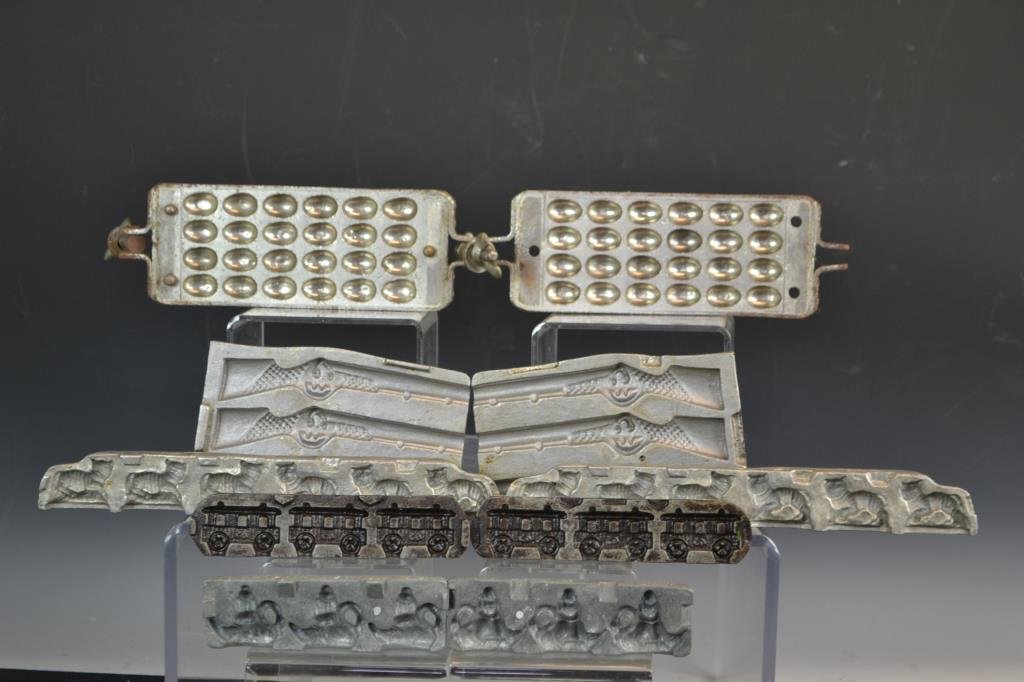 Five Clear Toy Candy Molds: Clear Toy Candy Molds in the form of; a cat, a teapot, train cars, a rifle, and traditional egg-shaped mold