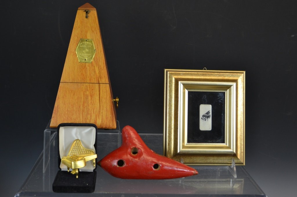 Musical Grouping: Musical grouping including a metronome by Seth Thomas, a redware Ocanara marked "Made in Germany" along with a gold plated pin in the form of a piano, and a small framed piano key with a scrimshaw pia