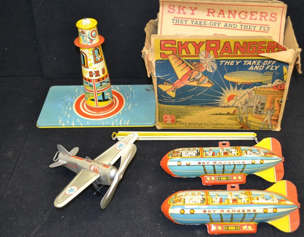 Boxes Sky Rangers Game: Unique Art Mfg lithographed tin, depicts lighthouse tower with circling zeppelin and key wind flyer monoplane, nice graphics. 9" h. 2nd Zeppelin Included.