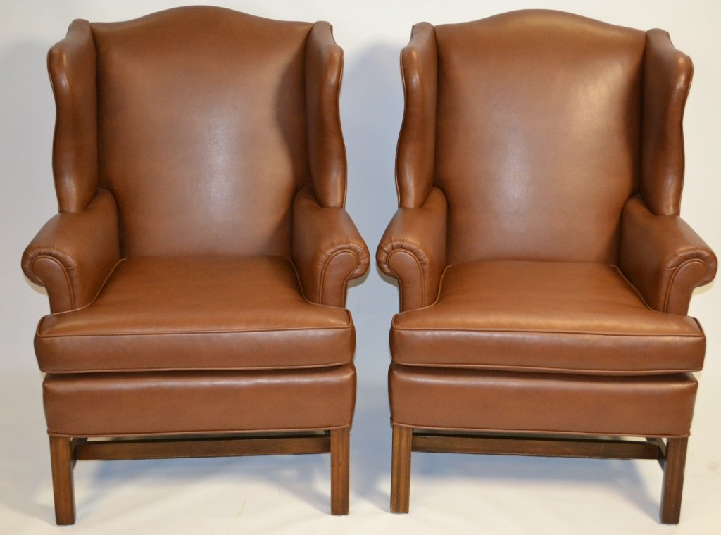 Two Brown Faux Leather Wing Back Chairs: Two Chippendale Style brown faux leather wing back chairs, measures 41"h x 28"w x 33"d
