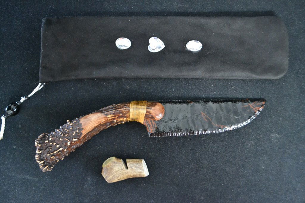 Handmade Obsidian Knapped Tony Stanfield Knife: Handmade Obsidian Knapped Tony Stanfield Knife with 7 inch knapped obsidian blade tied with artificial sinew to antler handle; pommel stamped with bear paw icon; 14 inches overall; comes with velour p