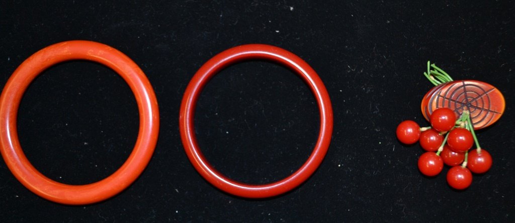 Grouping of Bakelite Jewelry: Grouping of Bakelite Jewelry including: 2 red bangle bracelets, 1 cherry pin