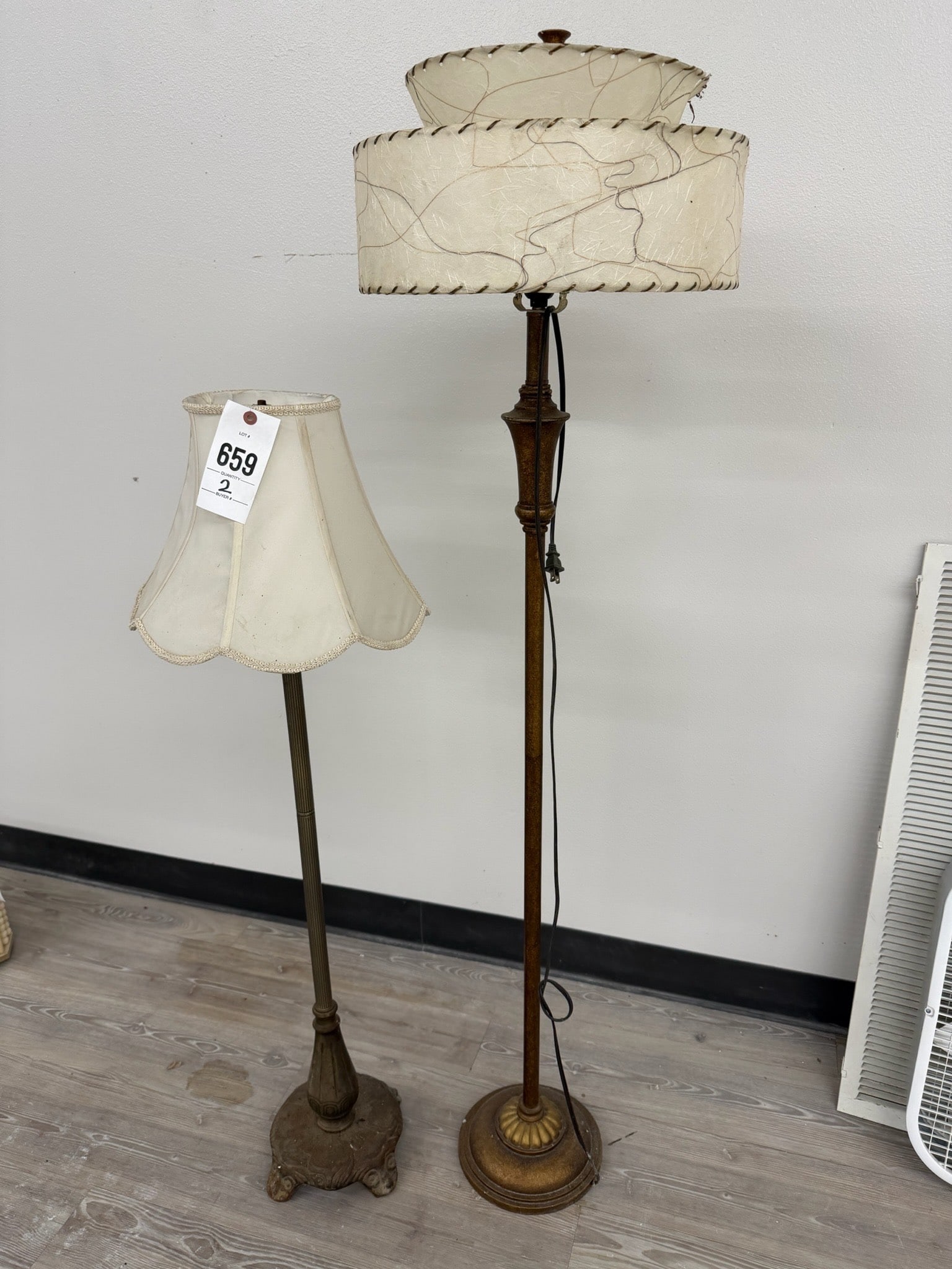 Floor Lamps with Fabric Shades: Floor lamps featuring decorative designs. One has a bronze-tone base with a scalloped, fabric lamp shade, and the other features a more ornate metal base with a double-layered, stitched fabric shade.