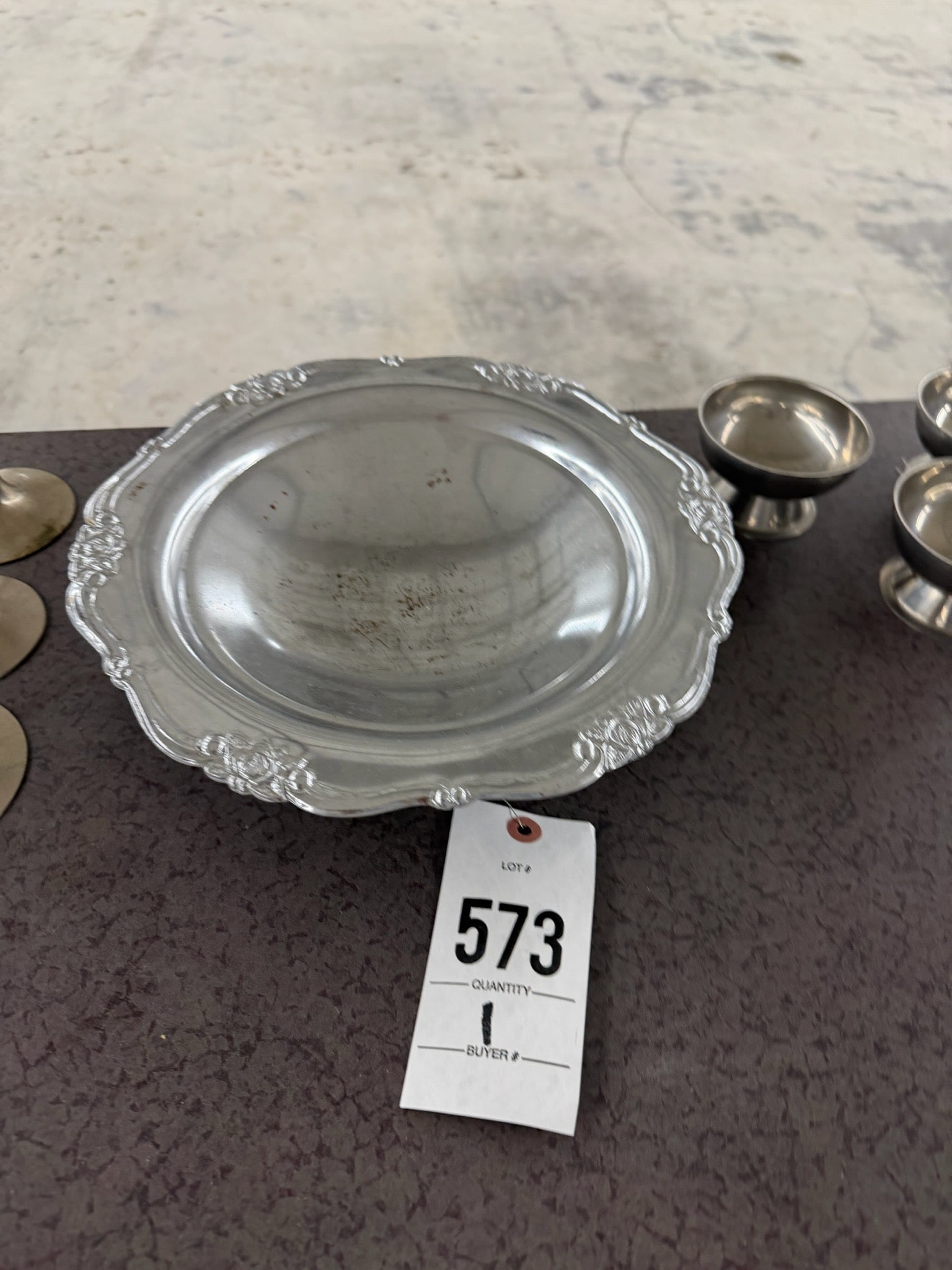Decorative Metal Plate with Ornate Edges: Decorative metal plate featuring an ornate floral design along the edges.