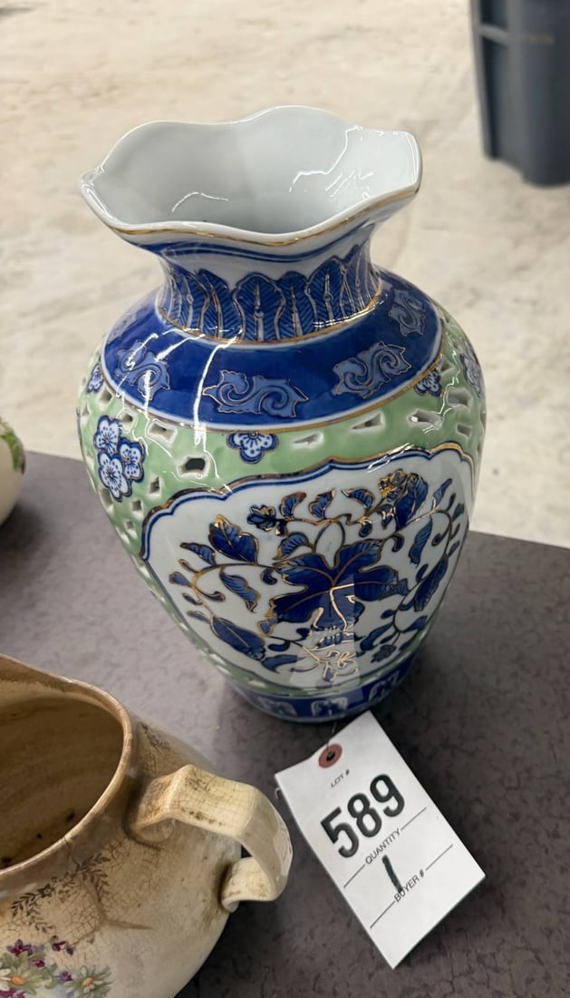 Decorative Porcelain Vase with Blue Floral Motif: Porcelain vase featuring a blue and white floral motif with intricate detailing. The vase has a fluted rim and is accented with additional colors in green and blue tones..
