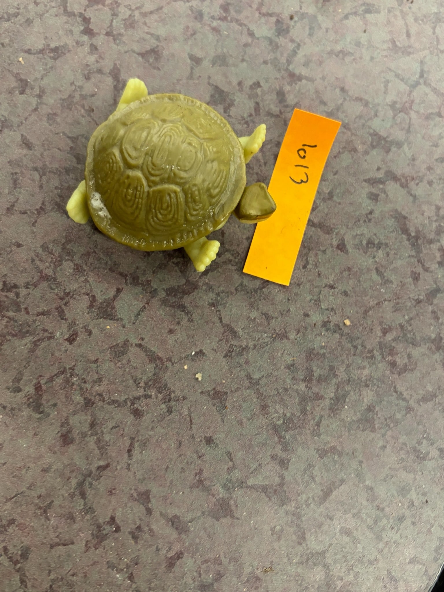 Small Green Plastic Turtle Figurine: A small green plastic turtle figurine, featuring a textured shell and realistically shaped limbs. The item is made of plastic and is compact in size, making it suitable for display or collection.