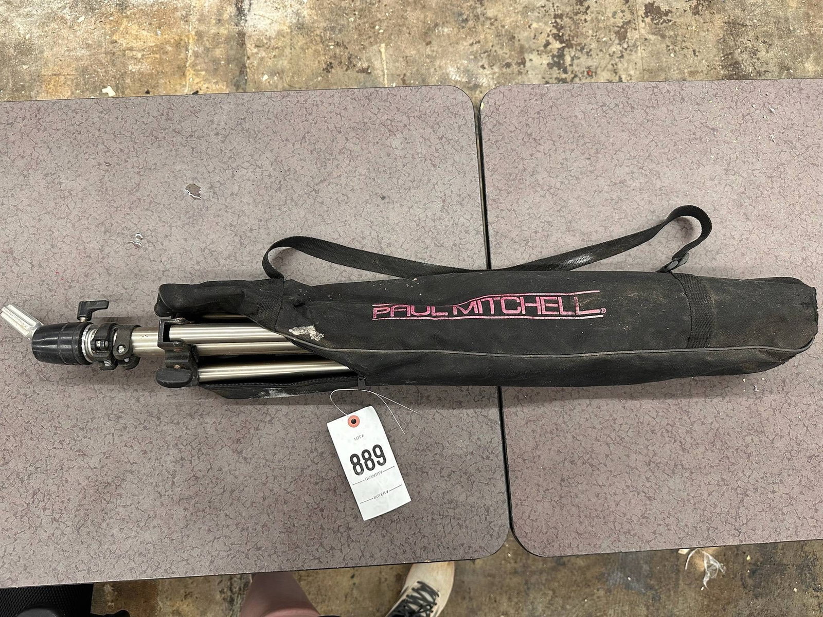 Paul Mitchell Cosmetology Tripod Holder: A Paul Mitchell Cosmetology Tripod Holder with an included carrying case. The tripod features a collapsible design for easy storage and transport. Elevate your hairstyling experience with the Paul Mit