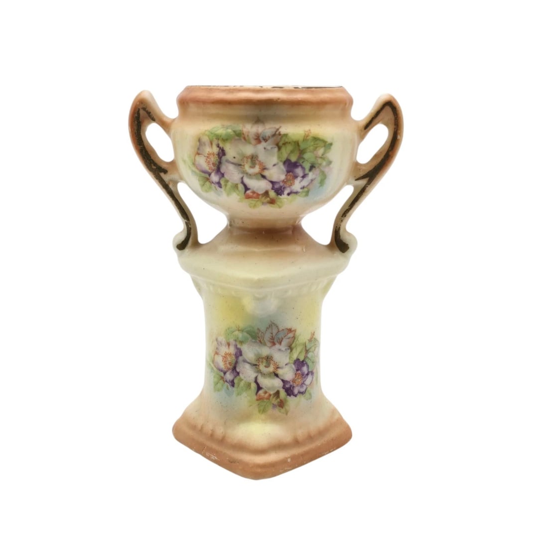 Vintage Miniature Porcelain Urn Vase - Double Handled Pedestal Budget Vase with Floral Design: A delicate and charming miniature porcelain pedestal vase featuring twin ornate handles and a soft pastel finish. Both the top urn and the square base are decorated with lovely hand-painted style whit