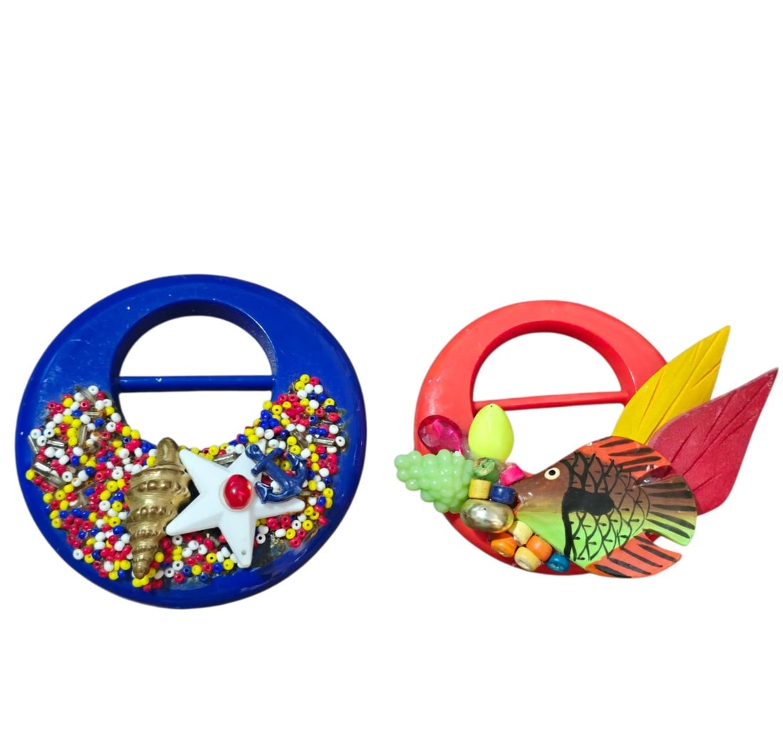 1970s Scarf Clips Lot of 2 - Mod Retro Nautical Shell & Colorful Pop-Art Fish Slides: Channel ultimate retro vibes with this lot of two unique 1970s-style plastic scarf clips!Clip 1: A bold cobalt blue round slide decorated with multi-colored seed beads, a white star, a miniature gold 