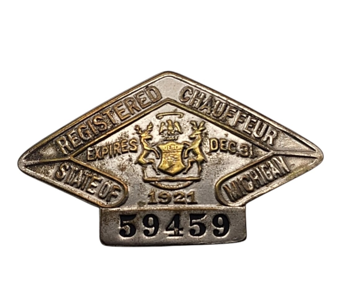 Vintage 1921 Michigan Registered Chauffeur Badge - Diamond Shaped Metal No. 59459: This distinctive diamond-shaped badge proudly displays the official Michigan state coat of arms embossed at the center, flanked by an elk and a moose under a vigilant eagle. The upper borders read "RE