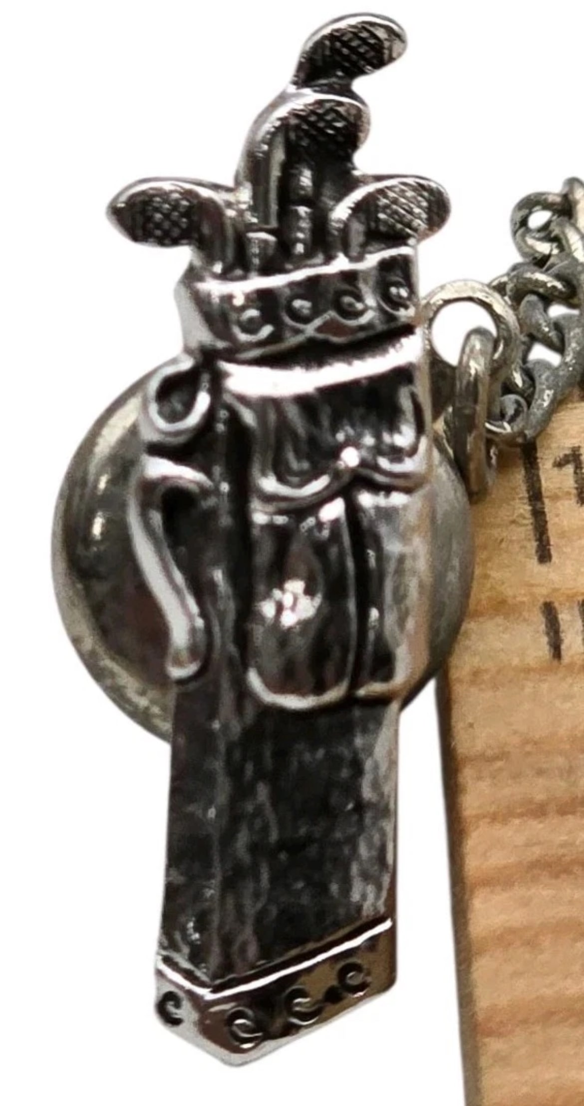 Vintage Silver Tone Golf Bag Tie Tack - Detailed Golf Clubs Lapel Pin with Guard Chain: This miniature piece features excellent detail, showcasing textured individual golf clubs peeking out of a pocketed cart bag with decorative scroll trim at the cuffs. The pin includes an attached safe