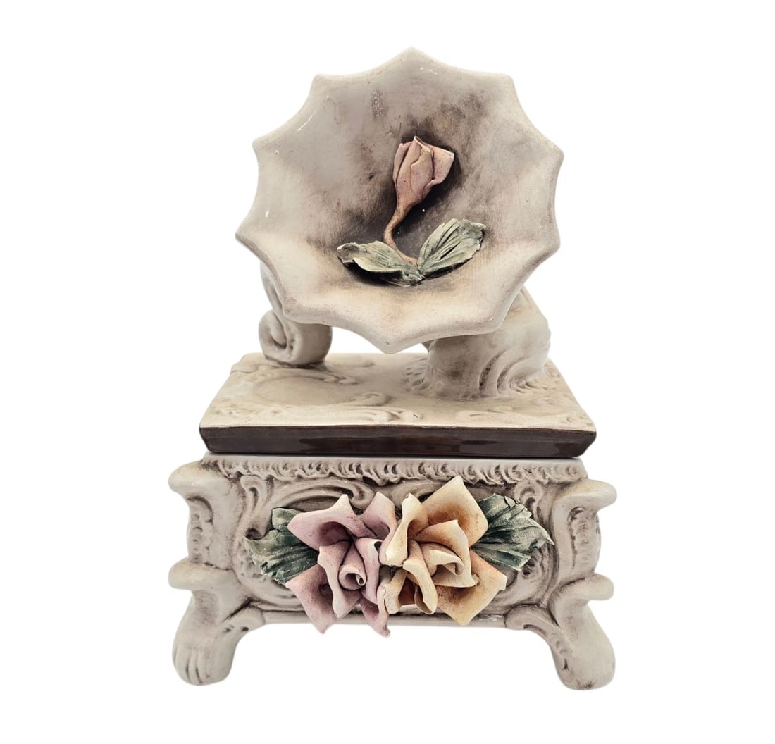 Capodimonte Porcelain Victrola Lid Trinket Jewelry Box Made in Italy 9" Tall: A unique, vintage-style footed jewelry box featuring a wind-up musical component. The front of the box is heavily embellished with dimensional pink and yellow sculpted roses nestled in ornate scrollwo