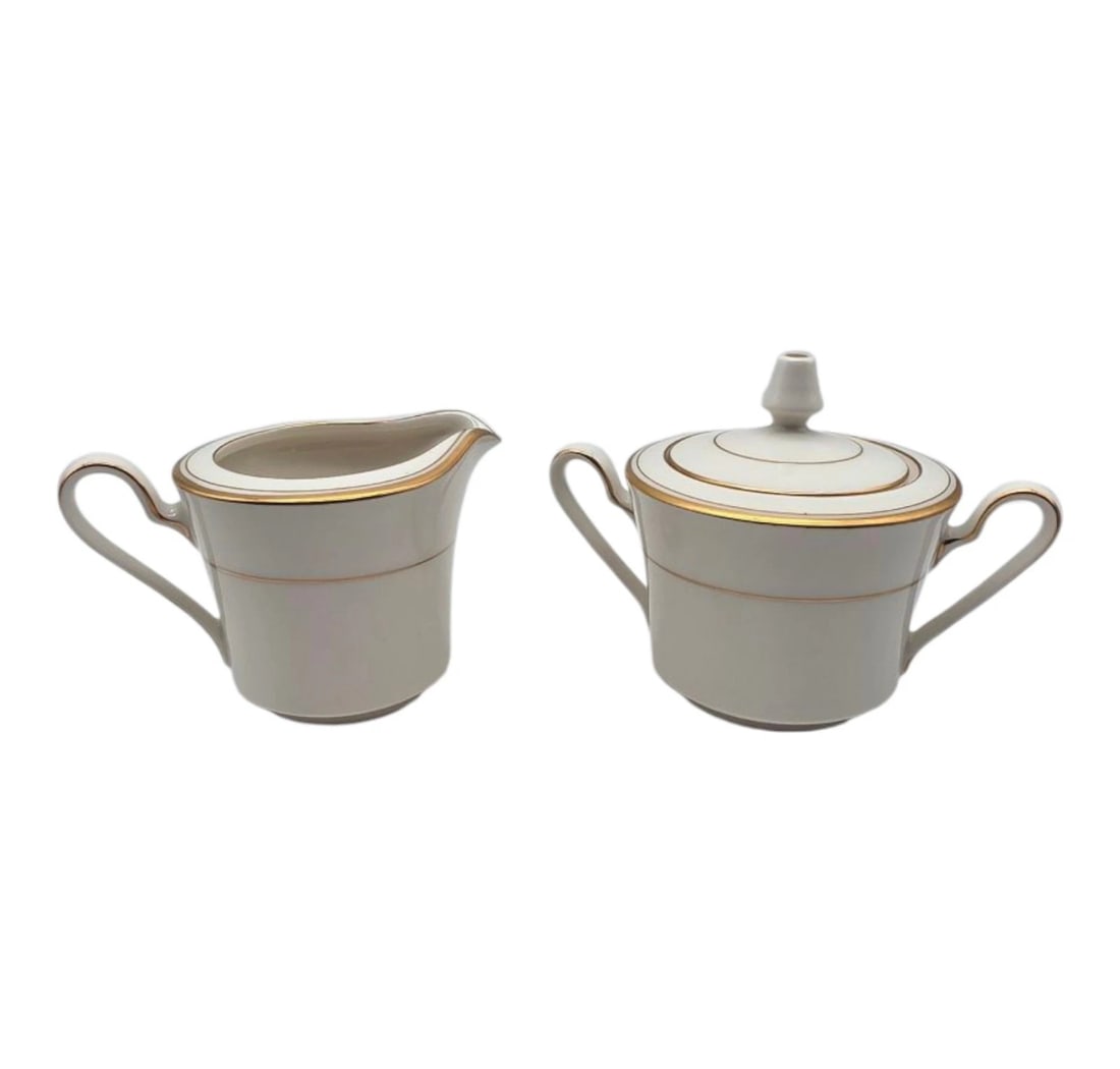 Noritake Linton Sugar Bowl With Lid And Creamer Set: An elegant two-piece fine porcelain cream and sugar set. Featuring a timeless minimalist design, this set includes a handled creamer pitcher and a matching double-handled sugar bowl with its original 