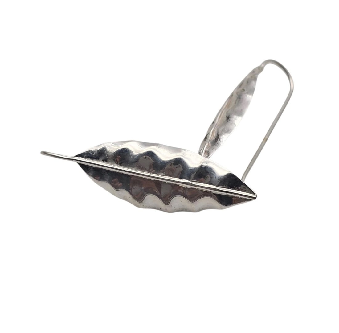 Mexico Made Sterling Leaf Pattern Lightweight Drop Earrings: sterling earrings Crafted in a stylized, elongated leaf silhouette with a distinct wavy, textured surface that catches the light, complete with a prominent central vein line.