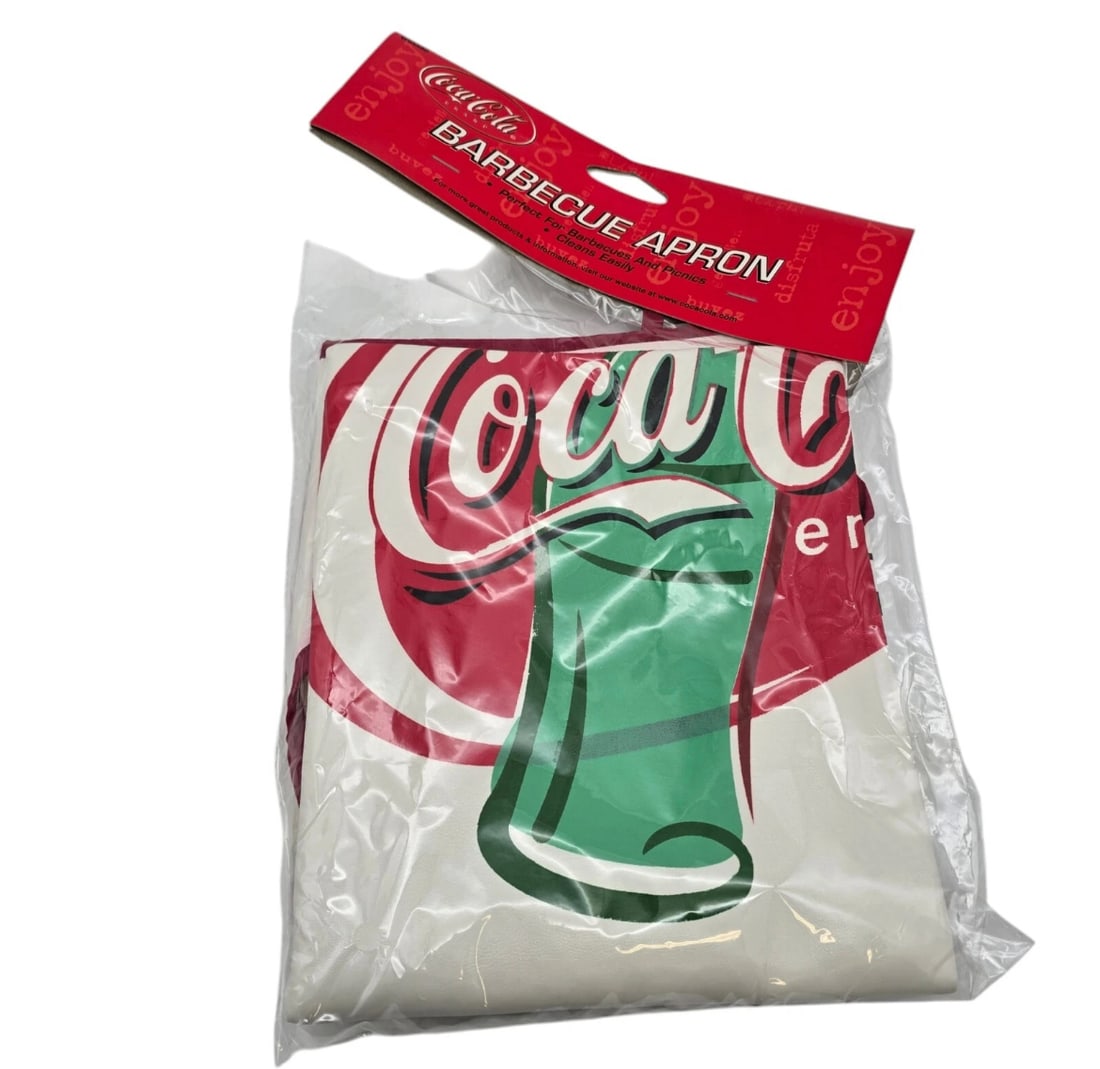 Coca-Cola Brand Vinyl Barbecue Apron (New in Packaging): this official Coca-Cola licensed Barbecue Apron features a bold graphic of the classic green contour glass bottle against the red and white script logo.