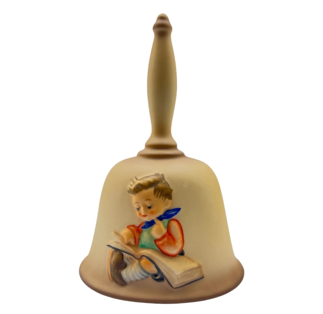 Vintage Goebel Hummel Figurine Second Edition Annual Bell 1980 HUM702: l hand bell showcasing a favorite classic theme. The relief artwork displays a young schoolboy deeply engrossed in a large storybook laid across his lap, accented by a bright red jacket and a blue nec