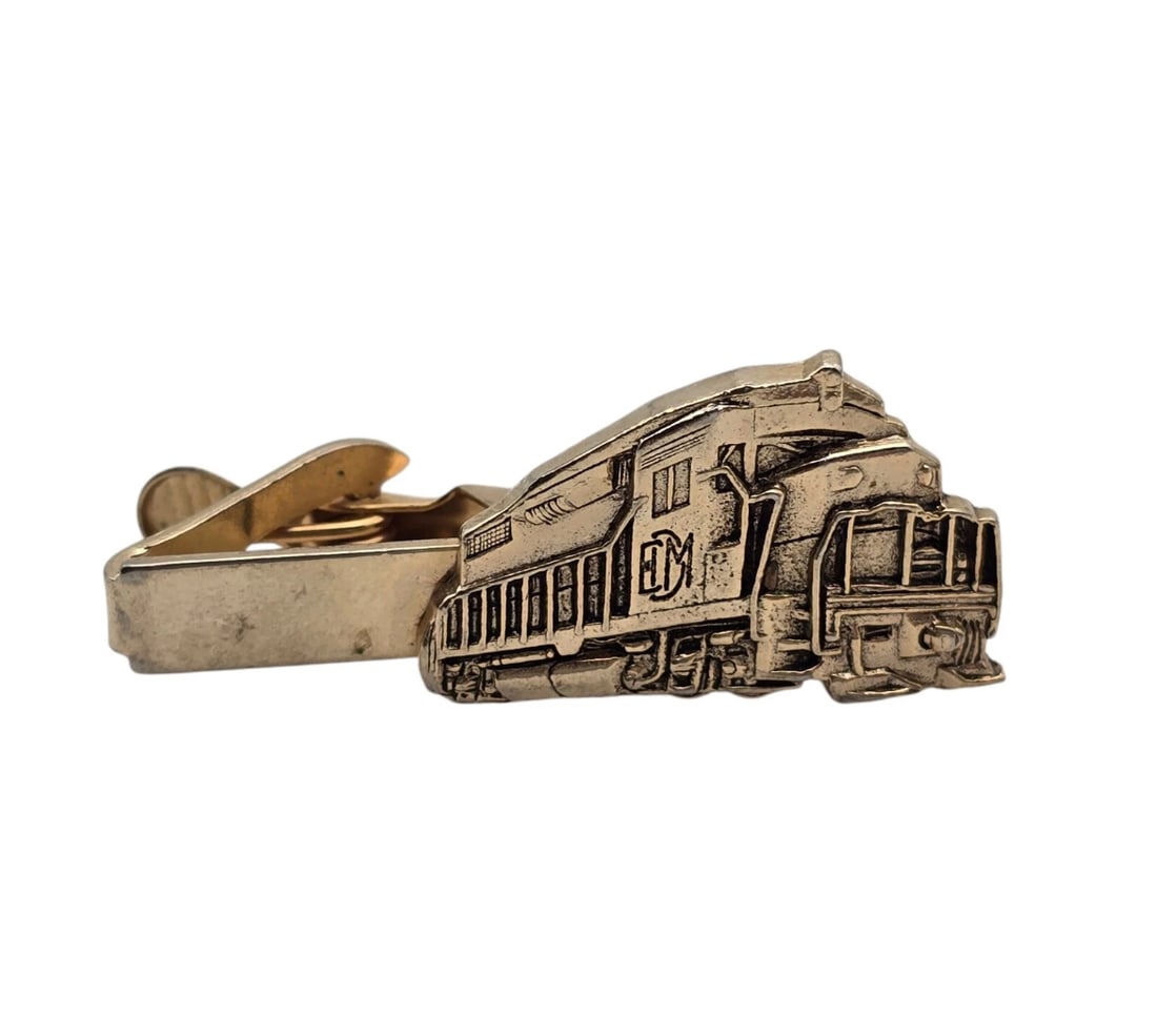 Vintage Mercury Industries Locomotive Tie Clip: A fantastic piece of railroad memorabilia, this vintage gold-tone tie bar features a highly detailed, embossed relief of an Electro-Motive Division (EMD) diesel locomotive train. The clip captures cri