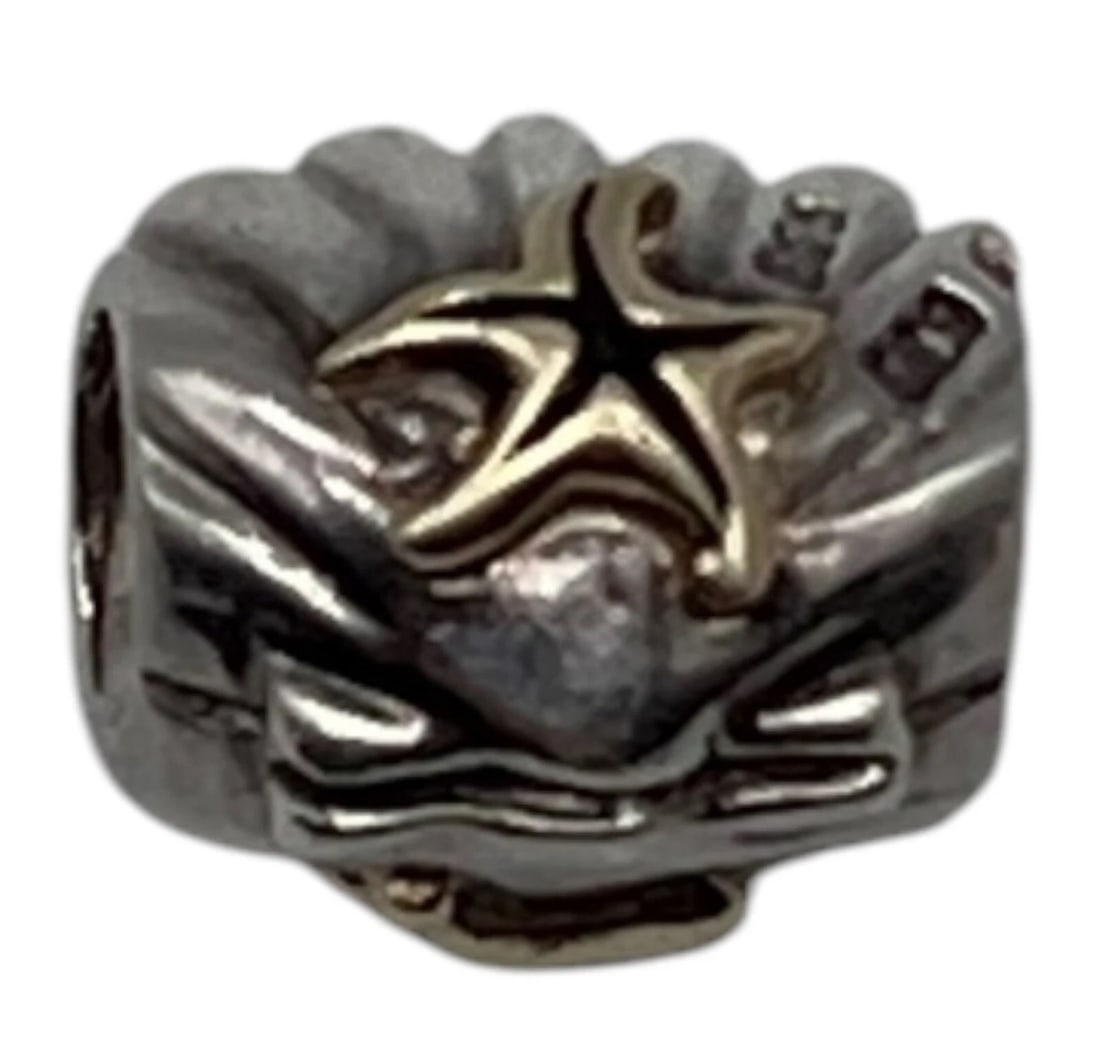 Chamilia Decorative 14K & Sterling Silver Charm Bead Shell With Starfish: A small, barrel-shaped openwork charm designed to fit a modular bracelet (such as a Pandora-style bracelet). The main body is crafted from antiqued sterling silver with a scalloped, shell-like texture