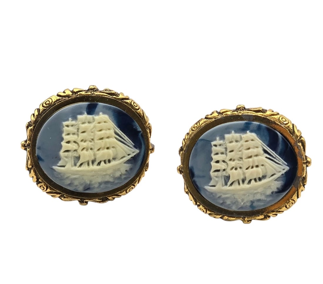 Dante Large Oval Gold Tone Incolay Cameo Clipper Ship Gray Cream: matching pair of oval vintage cufflinks or statement buttons featuring a crisp white relief carving of a three-masted sailing ship at sea. The detailed vessel is set against a swirled deep navy blue g