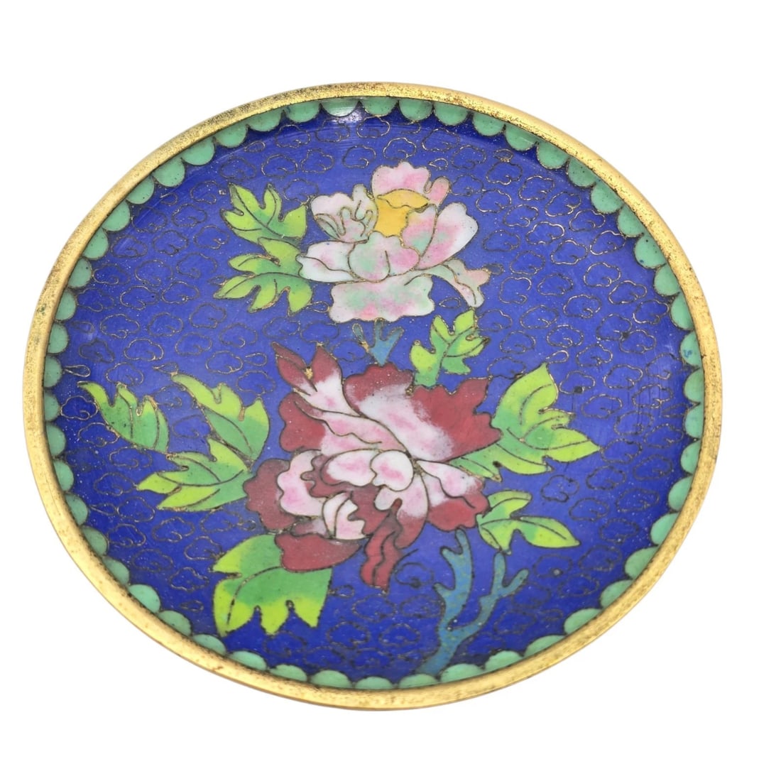 Cloisonne Saucer Vintage Chinese Blue With Blossom and Bottom Enamel: A round vintage Chinese cloisonné enamel pin dish or coaster featuring a rich royal blue background filled with traditional cloud scrolls. The center displays vibrant pink and red blooming peony flow