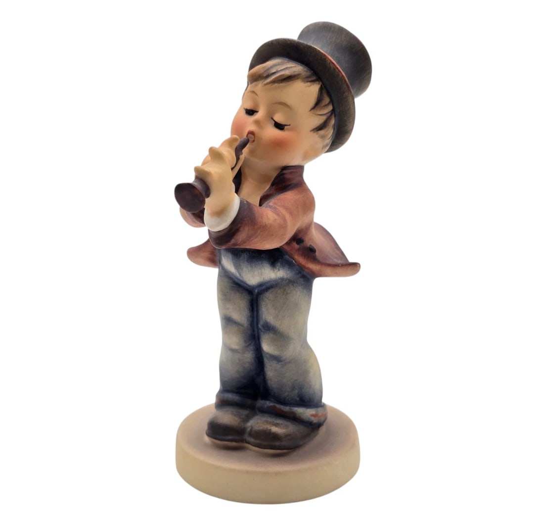 Vintage Hummel Goebel Serenade Little Boy Playing The Flute 5” Tall: A classic authentic Goebel Hummel fine porcelain figurine titled "Soloist" (No. 135). The figurine features a young boy singer/musician wearing a black top hat, a brown tailcoat, and blue trousers, en