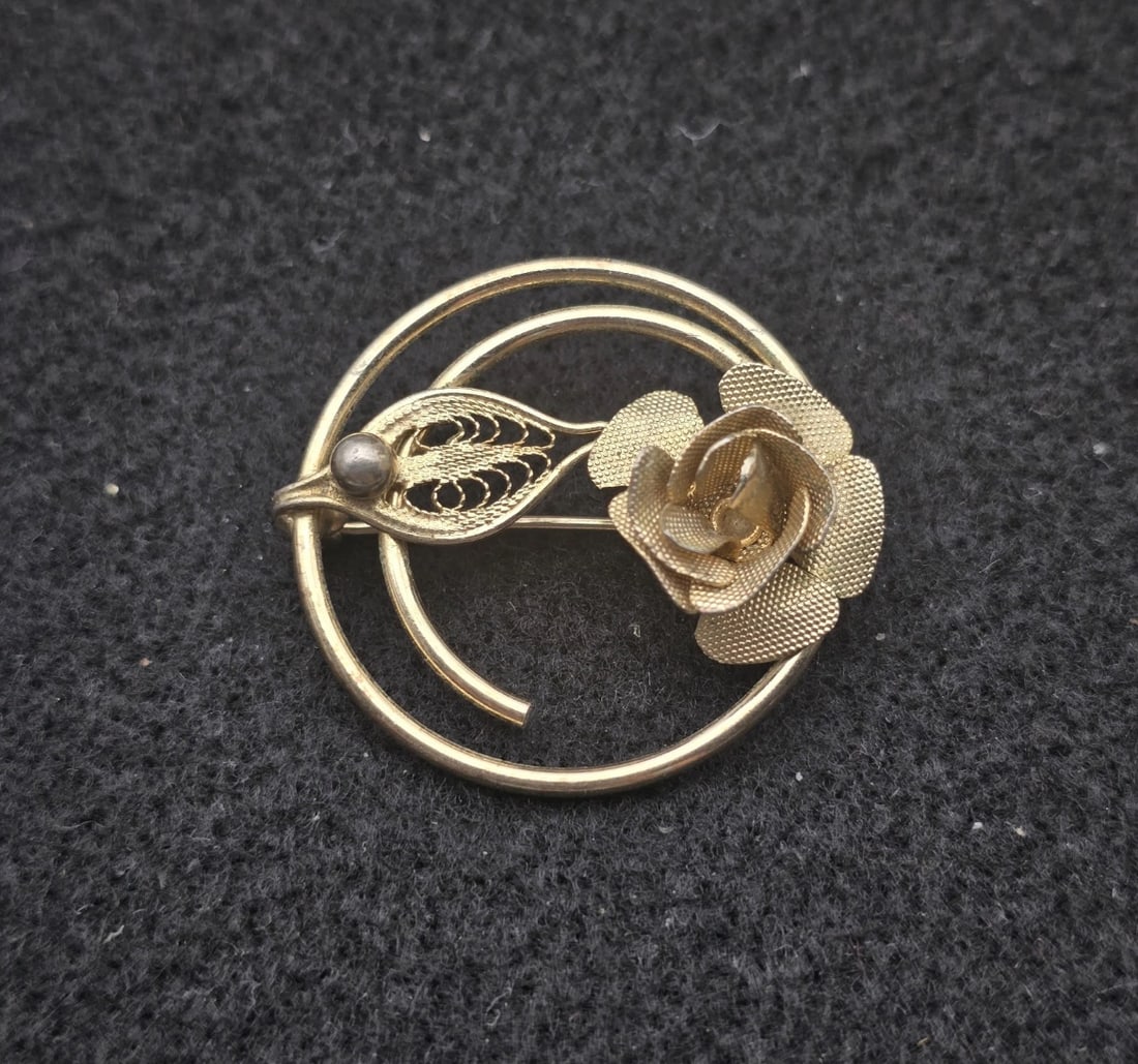 Signed SARAH COVENTRY Vintage Brooch Gold Tone Filigree Rose Leaf Coil: elegant vintage gold-tone open circle pin featuring a beautifully detailed three-dimensional rose flower. The design is accented by a delicate, openwork mesh filigree leaf and a single smooth metallic