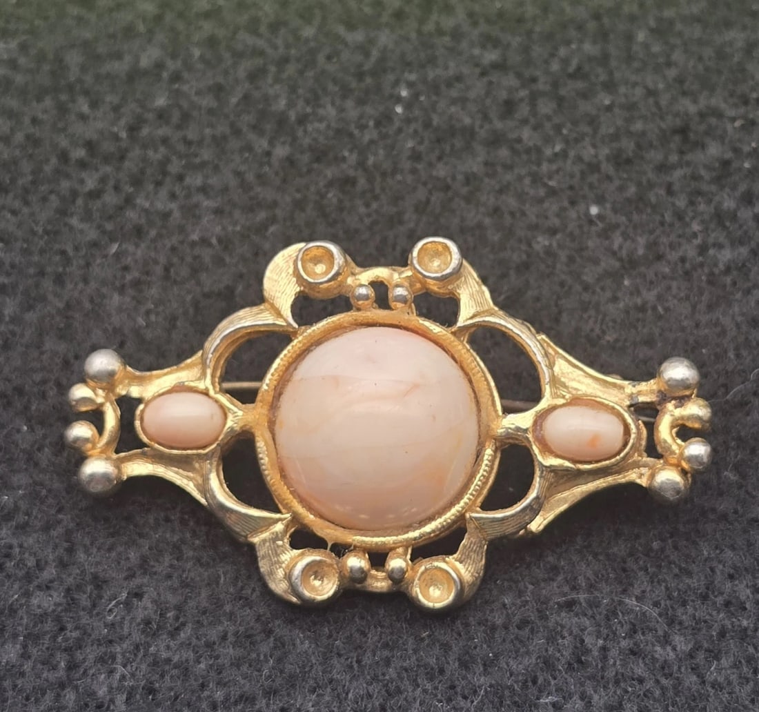 Vintage EXQUISITE Gold Tone Filigree Brooch Pin with Pink Cabochon Stones: A lovely vintage gold-tone openwork bar pin styled with scrollwork and small silver-plated accent beads. The center holds a large, smooth oval faux pink coral cabochon stone, beautifully balanced by t